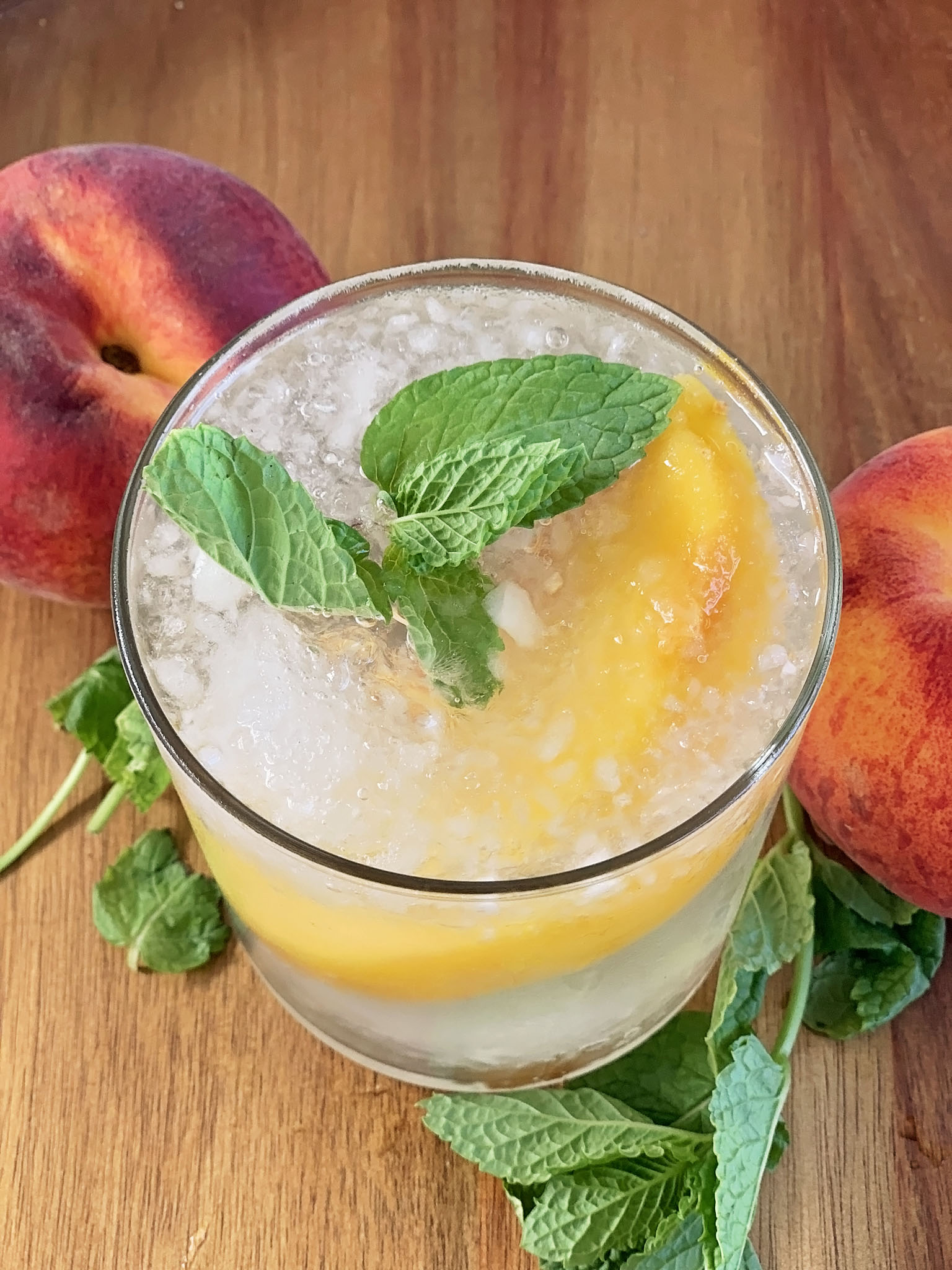 Sangria served over crushed ice and garnished with mint and peach.