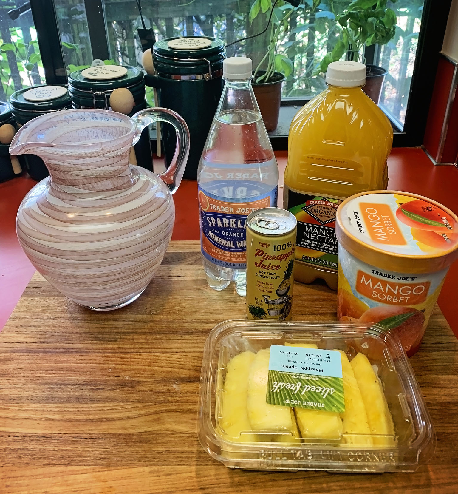 Ingredients for non-alcoholic mango and pineapple punch include Mango Nectar, Mango Sorbet, Pineapple Juice, Pineapple slices, and Sparkling Orange Mineral Water.