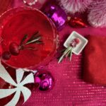 overhead shot of spiced cranberry negroni cocktail with holiday baubles