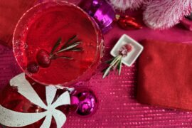overhead shot of spiced cranberry negroni cocktail with holiday baubles