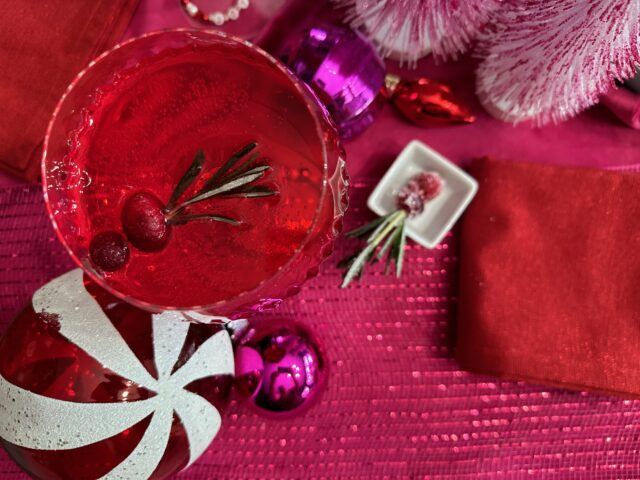 overhead shot of spiced cranberry negroni cocktail with holiday baubles